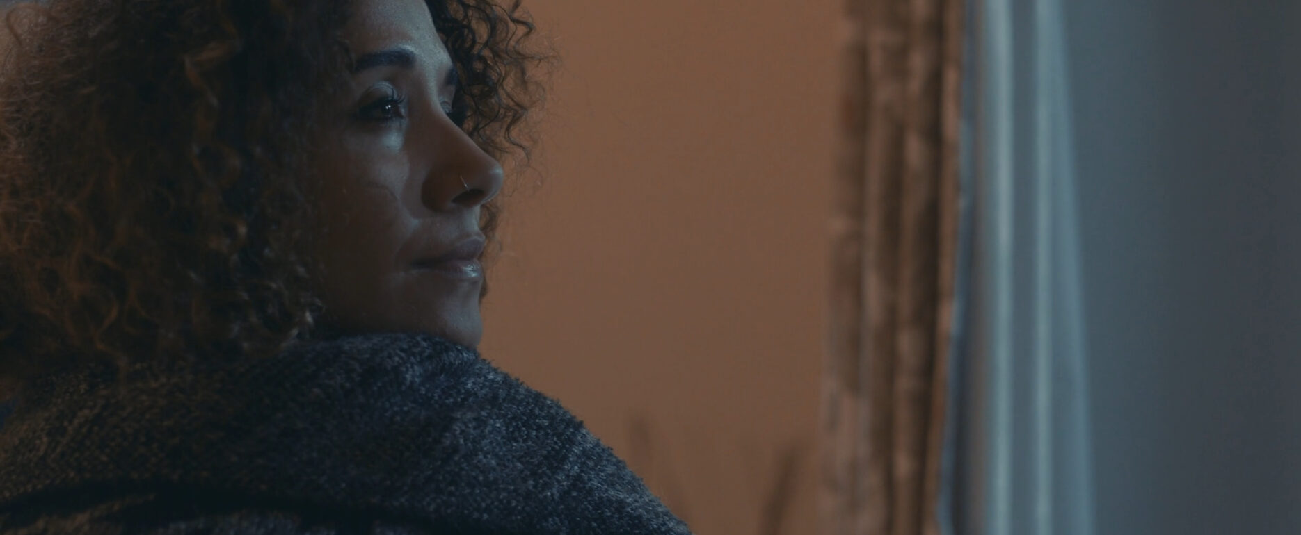 Woman gazing out of window during calm moment, peaceful atmosphere.